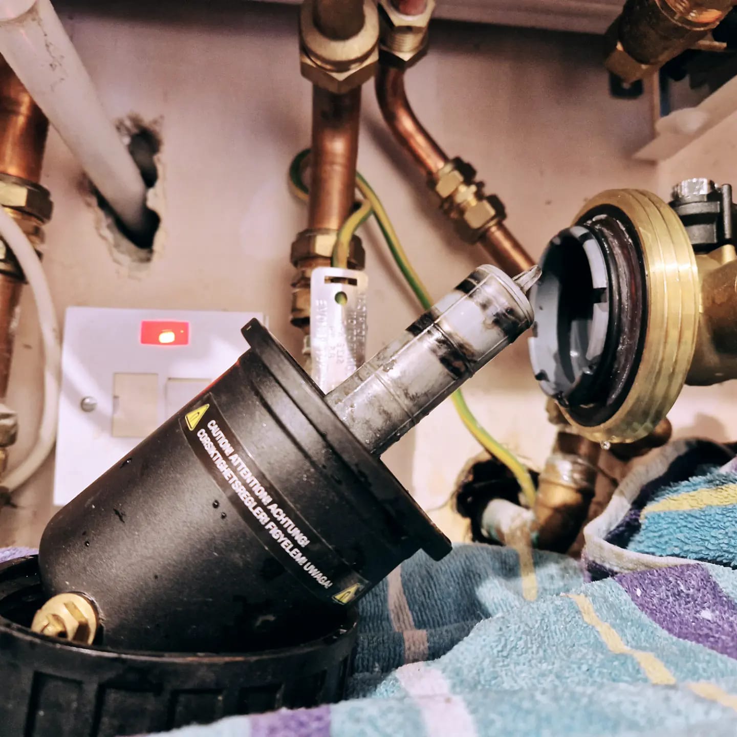 Boiler component lifted out during a service, with copper pipework behind